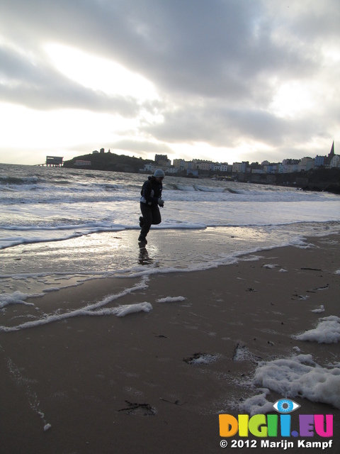 SX21393 Jenni runnig from waves on Tenby beach